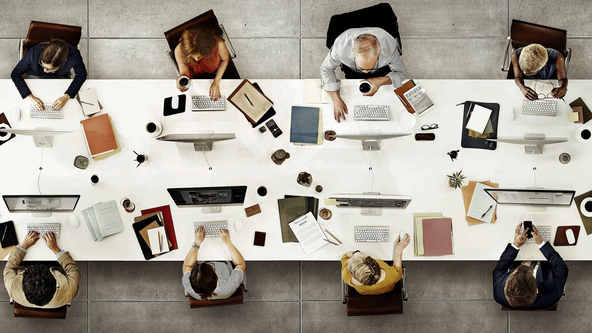Equipo de trabajo diverso reunido en torno a una mesa de oficina con computadoras, representando el uso colaborativo de árboles de decisión en entornos empresariales.